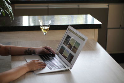 Midsection of woman using laptop on table