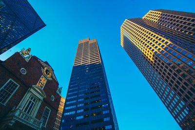 Low angle view of modern buildings against clear blue sky