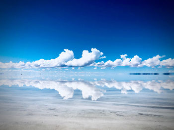 Scenic view of beach against blue sky