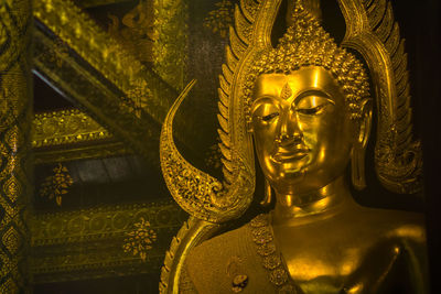 Close-up of buddha statue against temple building