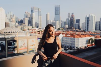 Portrait of beautiful woman against cityscape