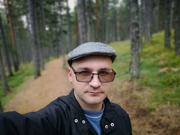 Portrait of man wearing eyeglasses while standing in forest