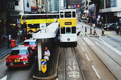 Man standing on bus in city