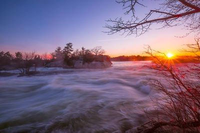 Scenic view of rushing water against sky during sunrise