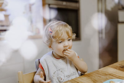 Cute girl eating food at home