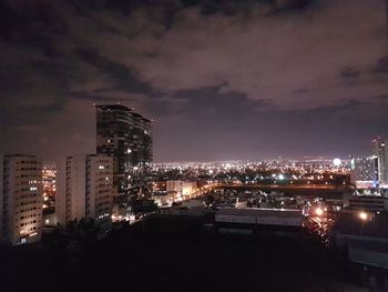 Illuminated cityscape against sky at night