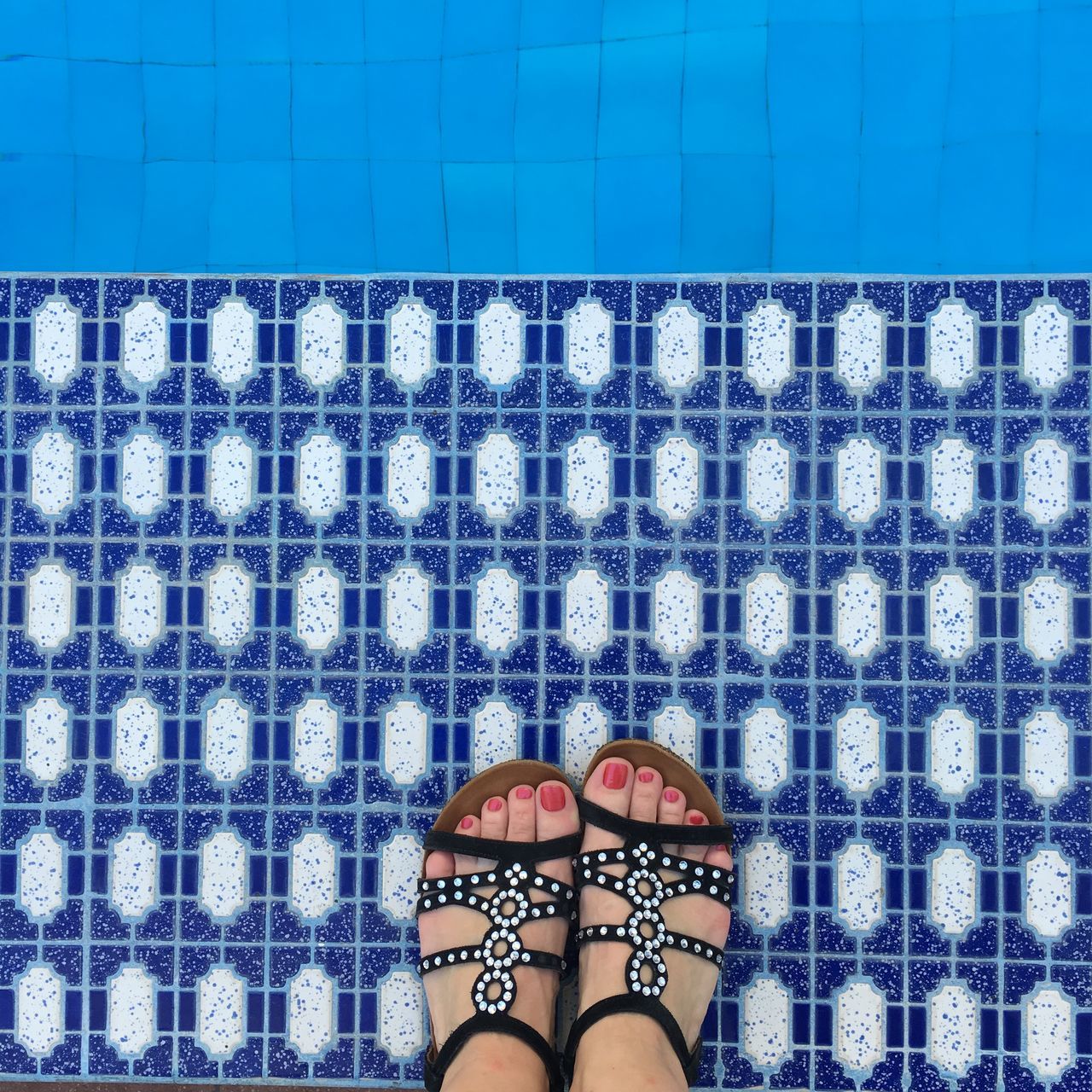 indoors, blue, pattern, design, text, close-up, tile, communication, white color, wall - building feature, textile, high angle view, still life, western script, directly above, tiled floor, floral pattern, creativity, fabric, checked pattern