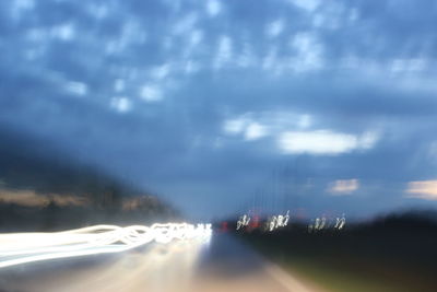 Light trails on road against sky