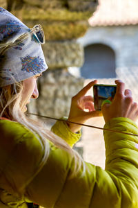 Portrait of woman photographing with mobile phone