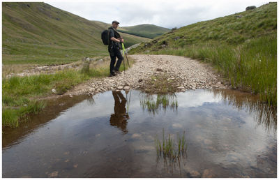 Full length of man standing on mountain against sky