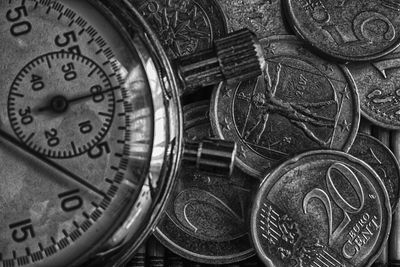 Close-up of coins and clock