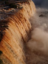 Scenic view of waterfall at sunset