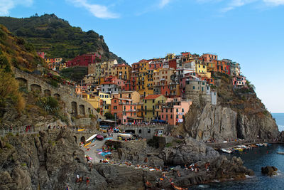 Buildings by sea against sky