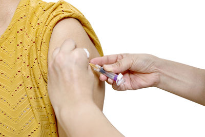 Close-up of woman holding hands over white background