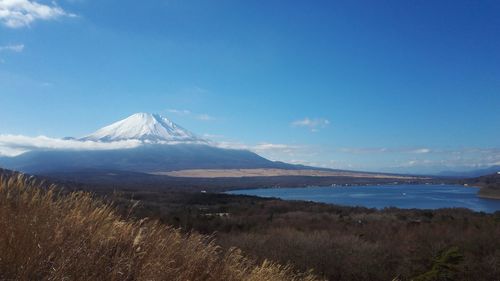 Scenic view of snowcapped mountains against blue sky