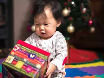 Cute baby girl with christmas gift at home