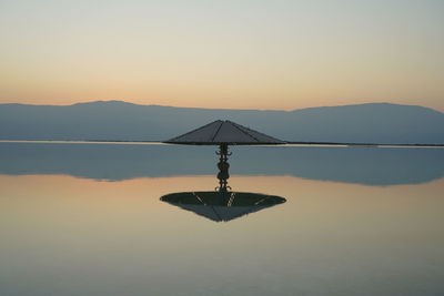 Sunrize on the dead sea.  umbrella reflection. 