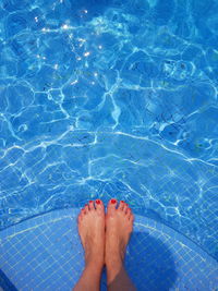 Low section of woman relaxing at poolside