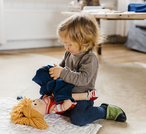 Cute girl sitting on toy at home