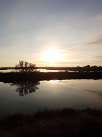 Scenic view of lake against sky at sunset