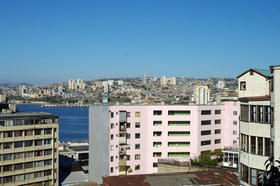 Buildings in city against clear blue sky