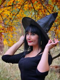 Portrait of smiling young woman standing during autumn