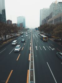 Traffic on road amidst buildings in city against sky