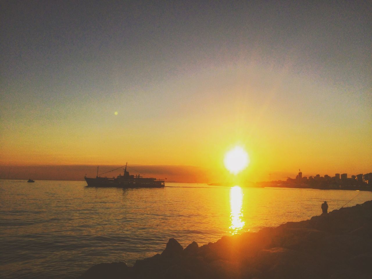 sunset, sun, water, sea, orange color, scenics, silhouette, beauty in nature, tranquil scene, nautical vessel, tranquility, reflection, sunlight, idyllic, nature, transportation, horizon over water, boat, sunbeam, clear sky