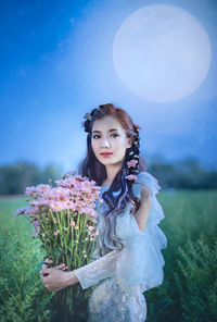 Portrait of beautiful woman standing on field