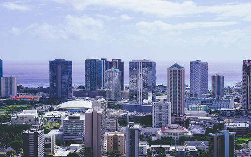 Aerial view of buildings in city against sky