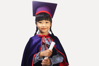Portrait of smiling girl standing against white background