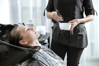 Woman getting hair colored in salon