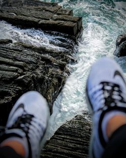 Low section of person on rock in sea