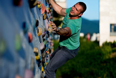 Low angle view of young man standing against sky