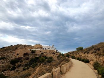 Castle on mountain against cloudy sky