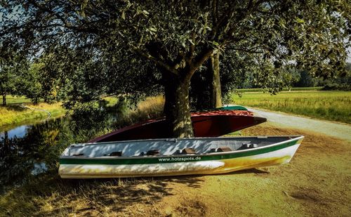 Boat moored on shore by lake against sky