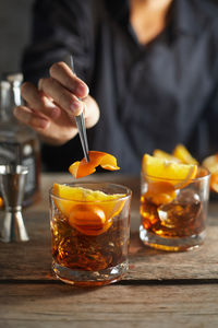 Midsection of woman holding drink on table