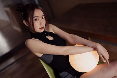 Portrait of young woman sitting on hardwood floor