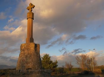 Low angle view of cross against cloudy sky