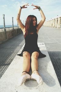 Young woman exercising on promenade