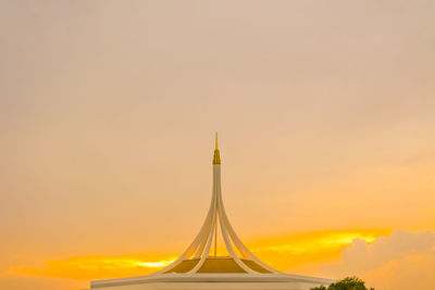 High section of cross against cloudy sky during sunset