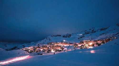 Aerial view of illuminated landscape against blue sky at night