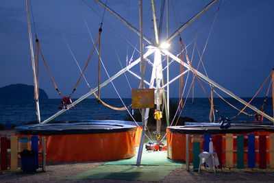 Sailboats moored on sea against blue sky