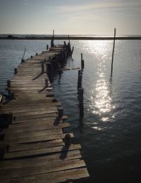 Jetty on sea against sky during sunset