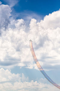 Low angle view of fighter planes performing airshow in cloudy sky