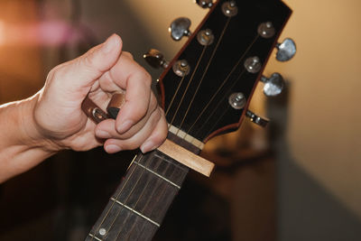 Cropped hand of person adjusting guitar
