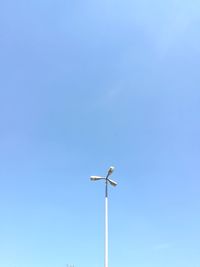 Low angle view of wind turbine against clear blue sky