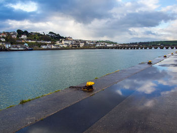 Scenic view of sea by buildings against sky