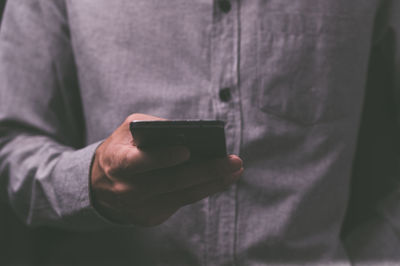 Midsection of man using mobile phone