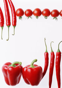 Close-up of red chili peppers against white background